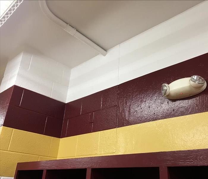 Restored and repainted ceiling and wall in a locker room. 
